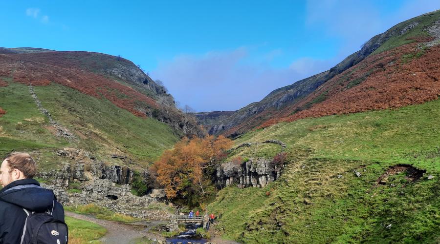 Autumn colours at wide waterfall , blue sky above
