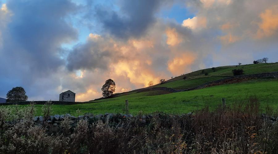 Autumn colours at wide waterfall , blue sky above