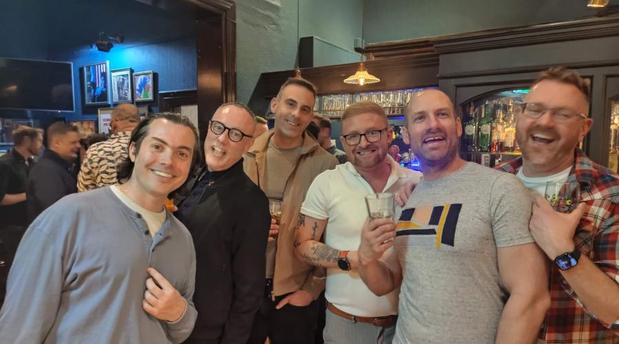 An event at Bingley Little Theatre showing people seated at tables and getting refreshments next to a pop up banner