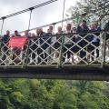 Guys on a bridge with an outdoorlads flag
