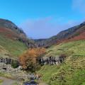 Autumn colours at wide waterfall , blue sky above