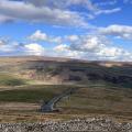 Autumn colours at wide waterfall , blue sky above